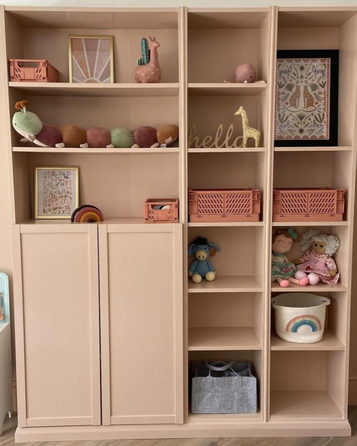 Blush pink kids storage unit from @thehouseof_rae with pastel accents and playful decorative toys.