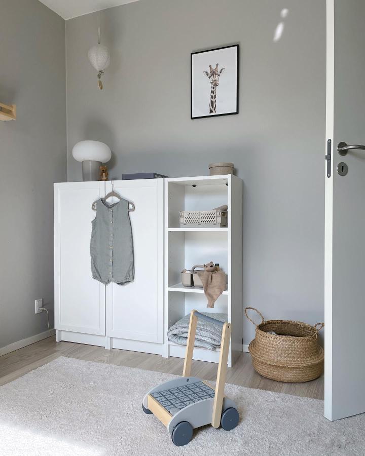 White Ikea Billy shelves and cupboard in a minimalist kids room from @annekkristensen featuring soft gray and natural woven storage ikea billy kids room ideas.