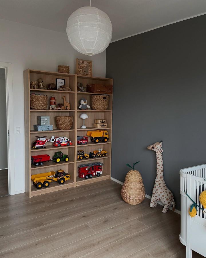 Natural wood Billy-style shelving from @nybygger_nr29 displaying kids toys and woven baskets with a minimalist, cozy vibe.