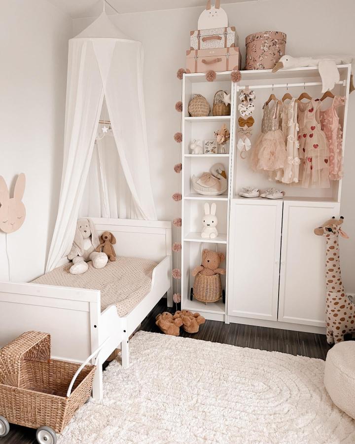 White Billy shelving unit with pastel storage and small hanging clothes in a kids room by @caritamaaret featuring soft textures and playful decor.