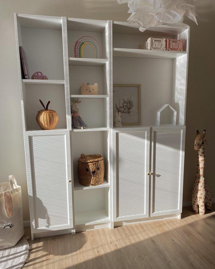 White minimalist kids shelving unit from @__lu_ci_e__. Bright, airy storage featuring natural baskets and playful pastel decor.