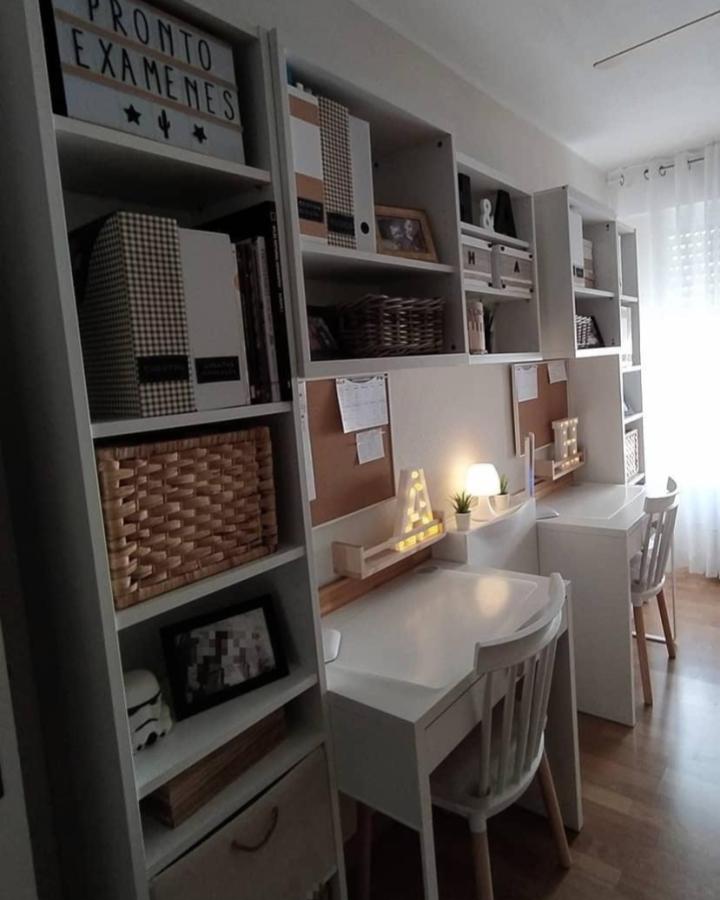 White Ikea Billy shelves with cozy kid study setup by @70stercita. Includes cork boards, storage baskets, and illuminated desk letters.