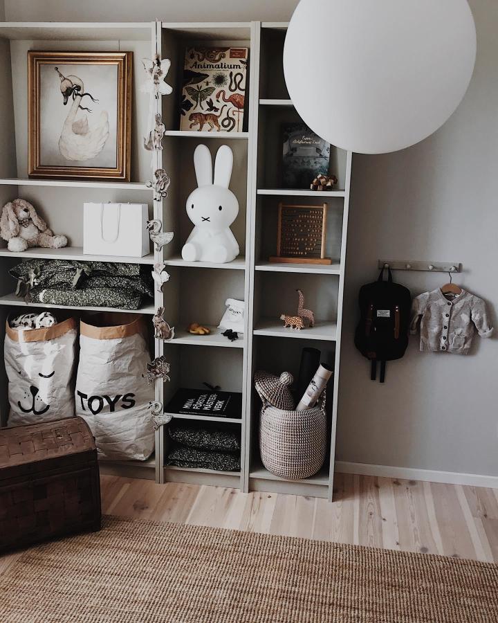 Soft neutral Ikea Billy shelving kids room idea by @emelie.westergren featuring cozy storage bags and playful decor in ikea billy kids room ideas style.