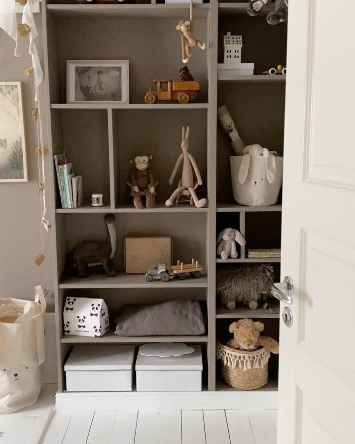 Neutral beige-gray Billy shelving with baskets and toys from @svartingstorpsmejeri showing organized child-friendly storage and decor.