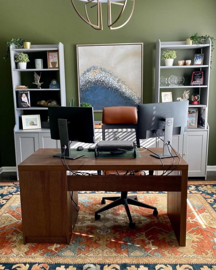 Warm wood desk and dual monitor setup with grey ikea hauga bookcases from @ash_hagood in a cozy green home office space ikea hauga ideas.