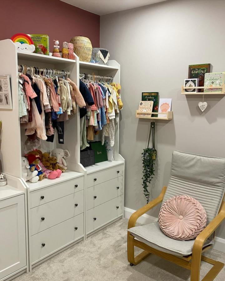 White Hauga storage units with pastel kids clothes and wicker baskets by @jadoredecor1. Cozy children's room with practical shelving and soft accents.