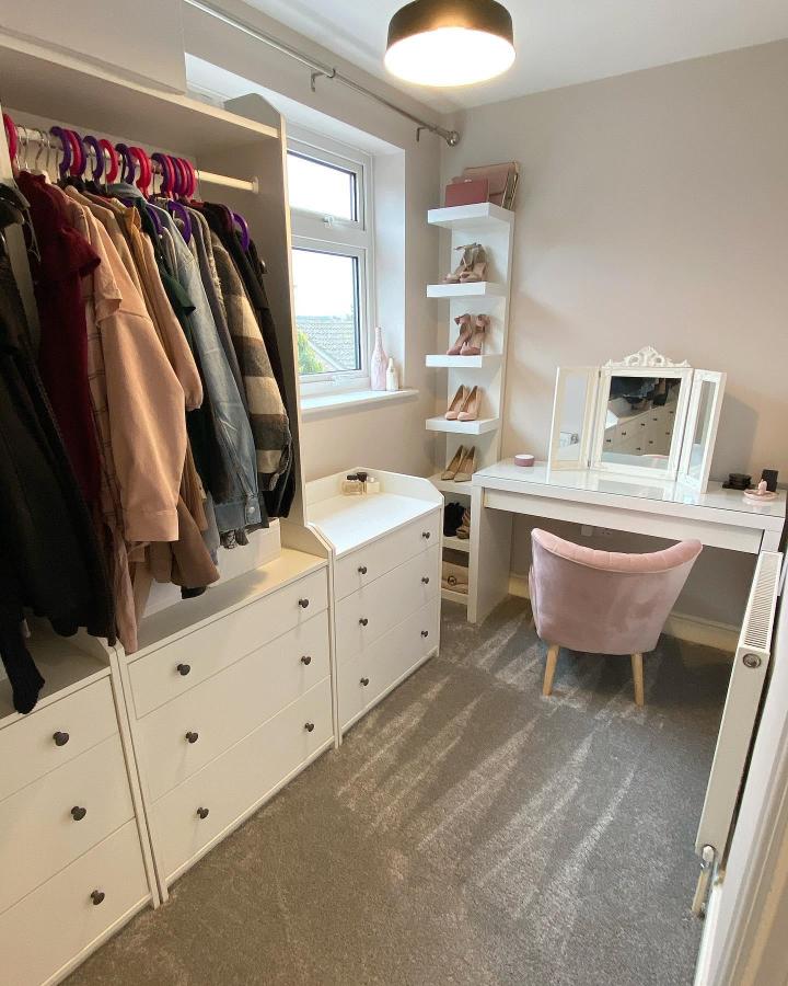 White and blush cozy dressing room with wall shelves and plush chair by @little_squares_of_no_5. Stylish storage and seating combo.