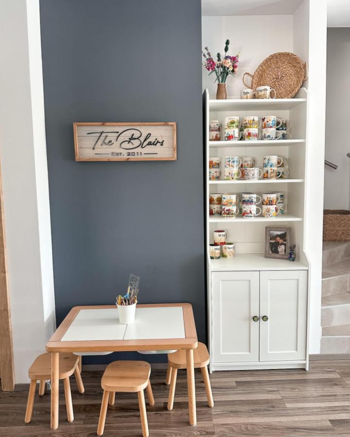 Natural wood kids table and stools with white ikea hauga cabinet from @serendipitousmommy showing a cozy collectible mug display in ikea hauga ideas setup.