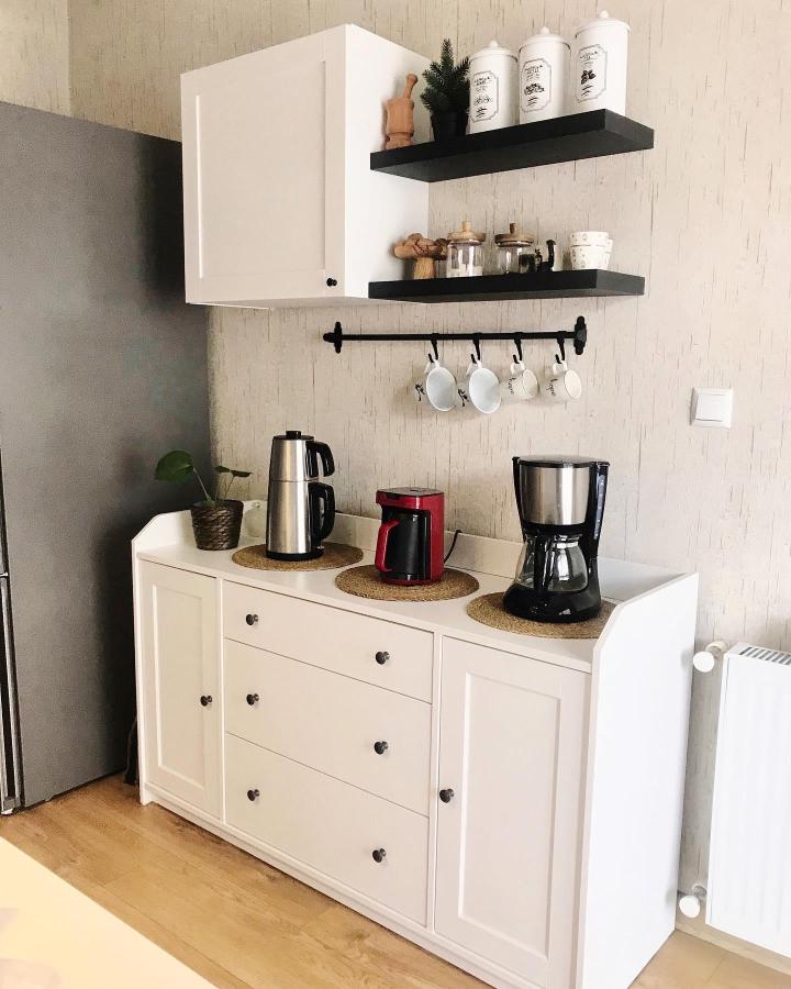 White and black kitchen shelving and cabinetry setup by @avine.___ featuring matte black floating shelves and cozy coffee station elements.