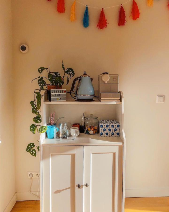 Creamy Ikea Hauga kitchen cabinet styled as a cozy coffee nook with colorful tassel garland and pastel kettle by @yaninaskitchen. Bright and inviting corner setup.
