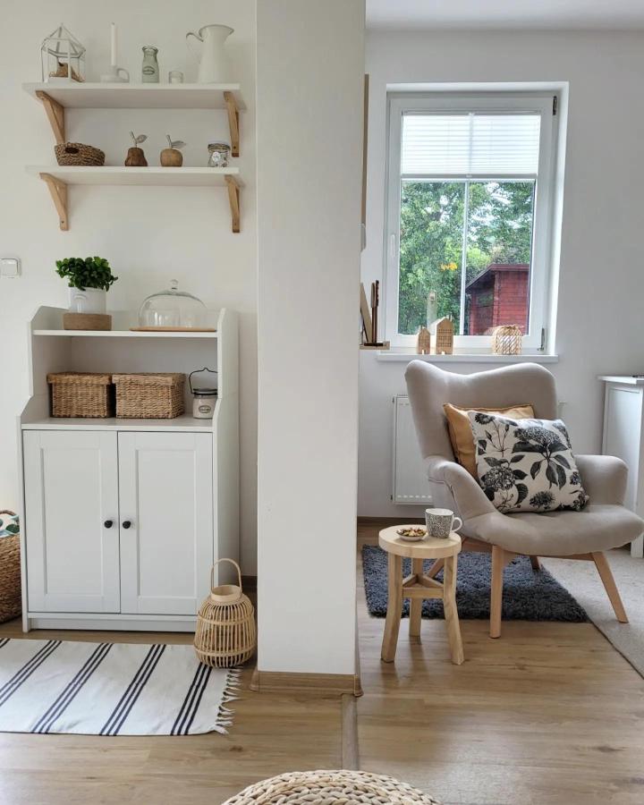 Beige armchair with floral pillow and white Hauga cabinet by @moje.bile.doma capturing neat ikea hauga ideas in a cozy living space