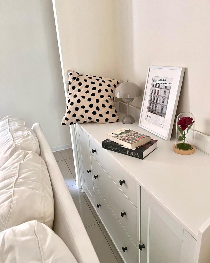Beige polka dot pillow on white Ikea Hauga sideboard with taupe lamp and framed photo from @natalie.home.life featuring ikea hauga ideas.