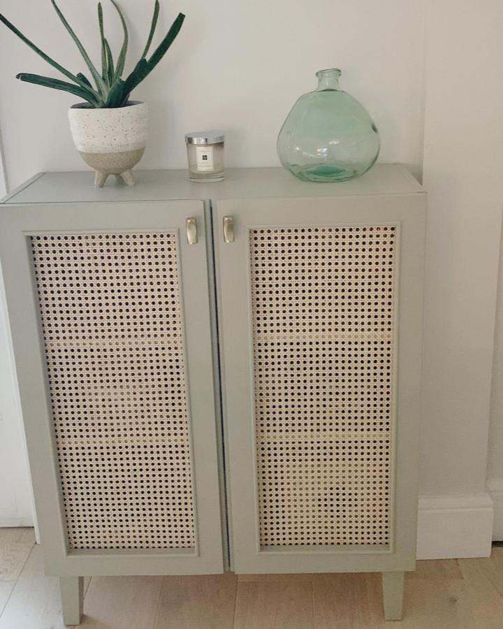 Light sage green Ikea Ivar cabinet hack with natural woven cane doors by @djungelhemmet showing elegant storage upgrade and texture.