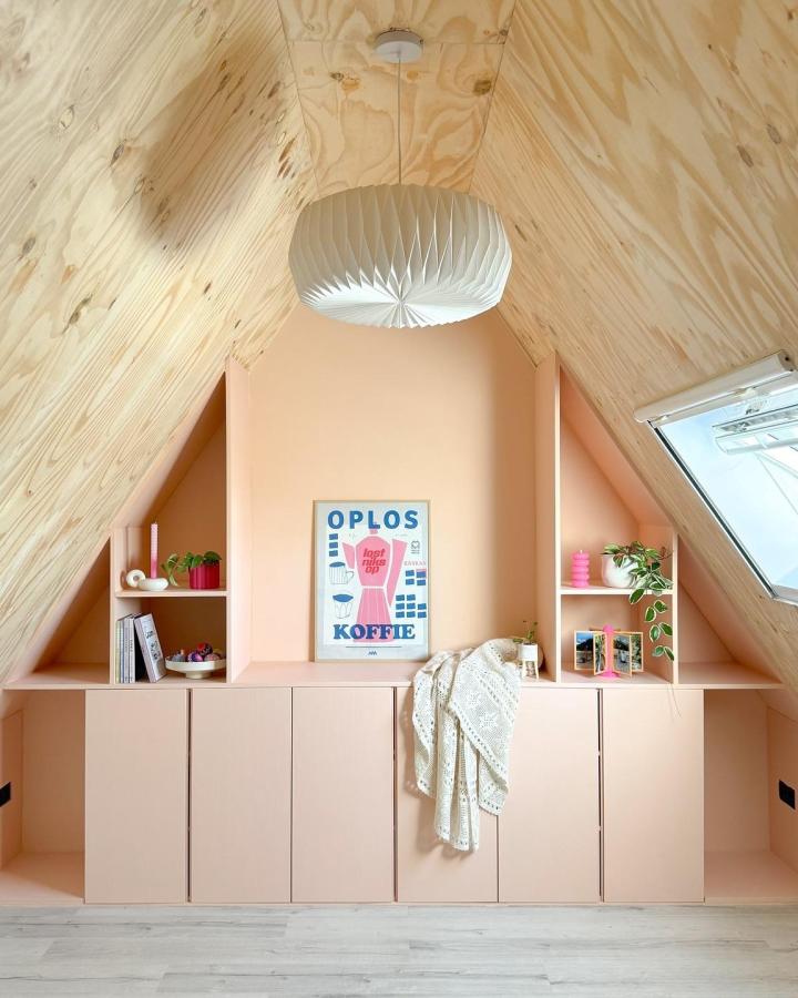 Soft pink painted Ikea Ivar cabinet hacks from @hmsewsit in attic space with angled shelves and light wood ceiling.