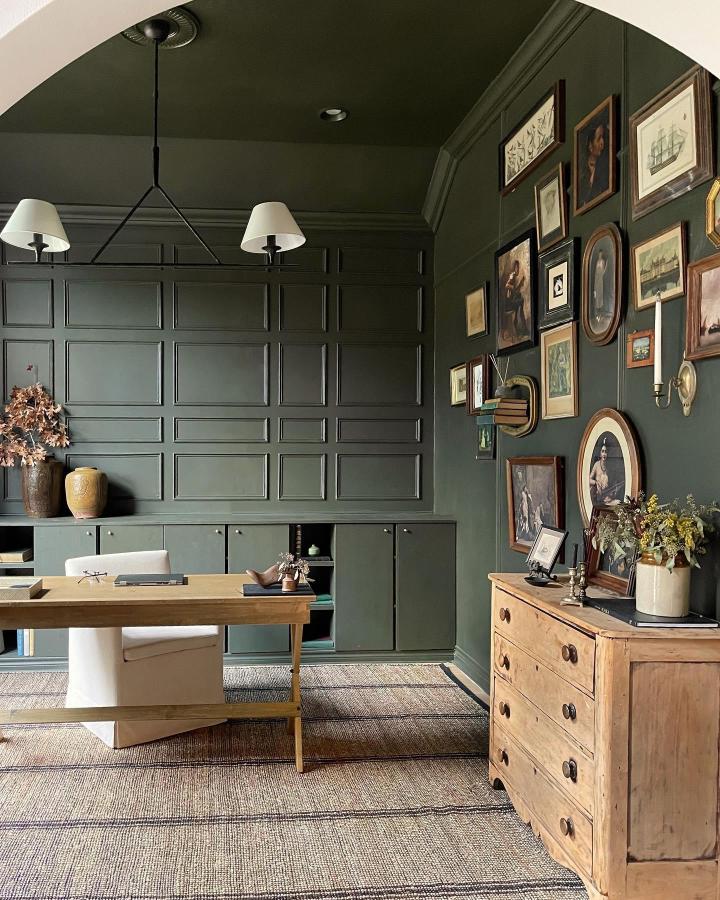 Olive green built-in storage cabinet with panelled details blending into wall from @photowall_sweden. Seamless custom storage solution in home office.