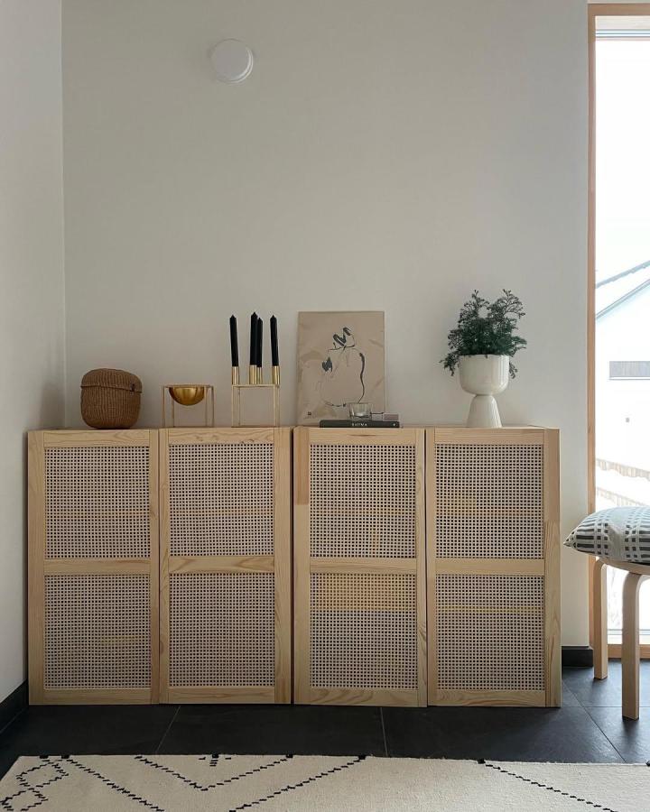Natural wood and rattan cabinet doors in modern living space from @mialehikoinen featuring stylish woven panel replacement on classic storage units.