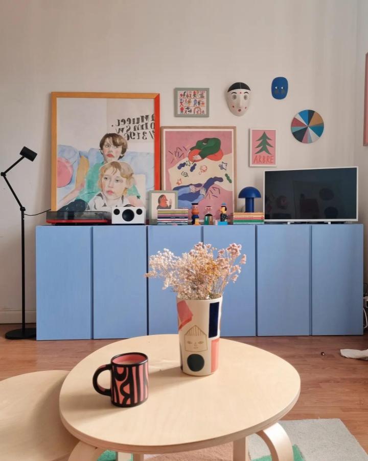 Sky blue painted Ikea Ivar cabinet from @wolfnoodle_ with colorful art and minimalist design in cozy living room.