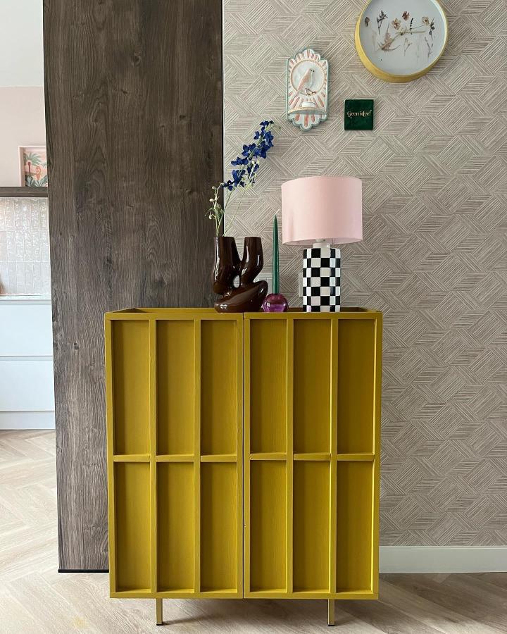 Mustard yellow painted wooden cabinet with custom slatted doors and metal legs by @_an_styles_ in stylish modern room setting.