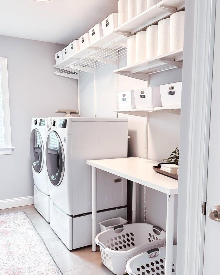 White minimalist laundry nook with Ikea BOAXEL shelves and labeled bins by @cleanhousetink, clean and organized space.