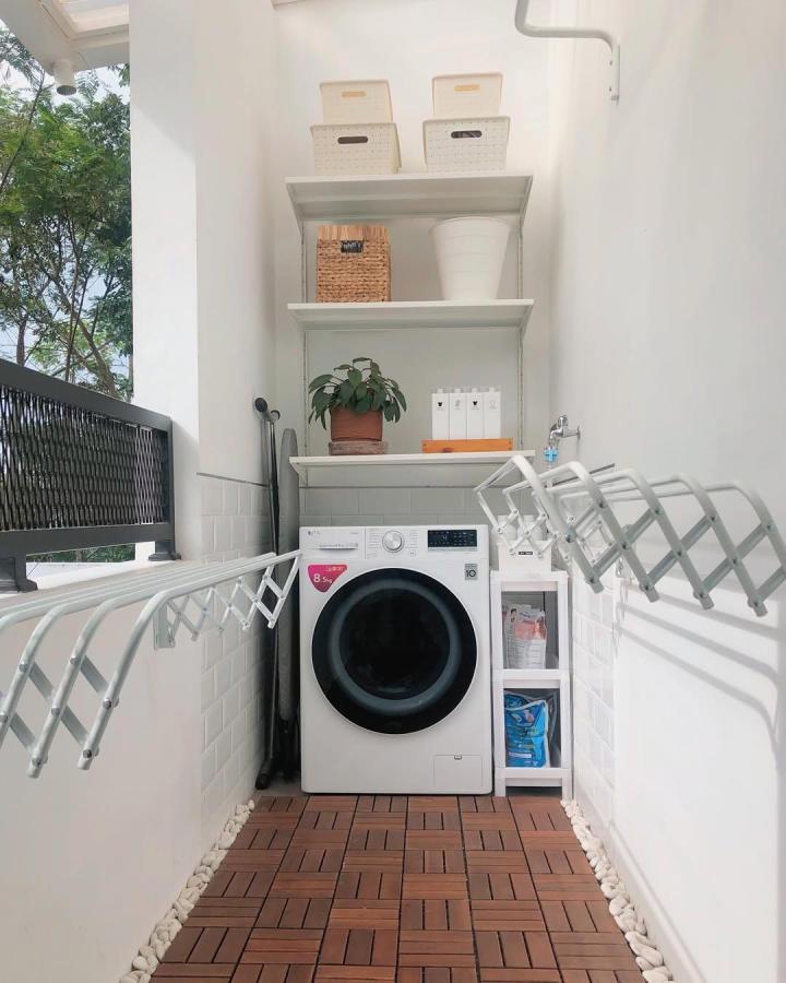 White minimalist laundry nook with BOAXEL system by @our.anhouse featuring wooden tile floor and compact drying racks.