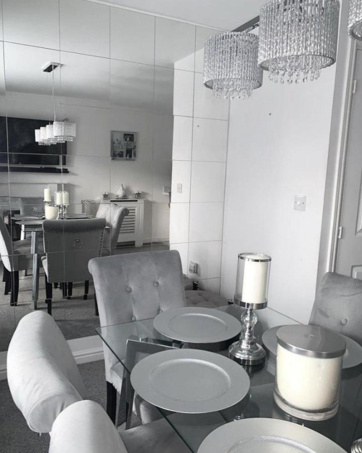 Grey mirrored panel wall in dining room from @mrslhome. Reflective surface with grid pattern enhances space and light.