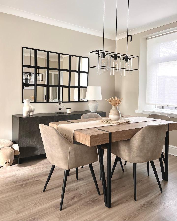 Neutral grid framed wall mirror in a bright dining space from @homewithgeorgia_ featuring black metal accents and warm décor elements.