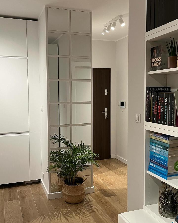 Light framed mirror panel wall in entryway by @40m2_agi reflecting natural light and expanding space visually.