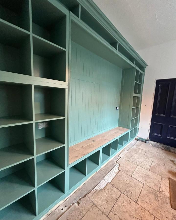 Soft green KALLAX mudroom storage and bench with wood seat from @homeontheparade. Spacious and stylish cubbies and seating.