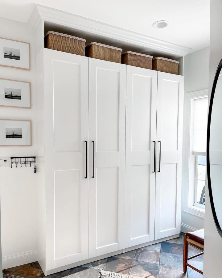 White PAX wardrobes with GRIMO doors in mudroom storage setup by @spikedteaandpeonies featuring baskets and black handles. Bright and tidy.