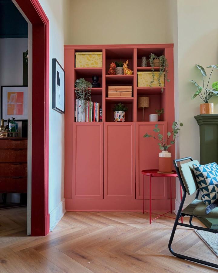 Warm terracotta built-in Ikea Billy bookcase painted coral with open shelves, colorful decor, and plants by @terrace.on.warwick painted ikea billy bookcase ideas