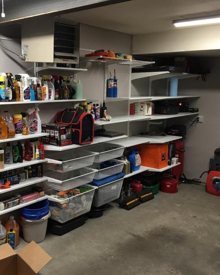 White Ikea Algot wall-mounted storage system with clear bins and shelves in garage from @deneenco showing practical ikea garage storage ideas. Organized and functional.