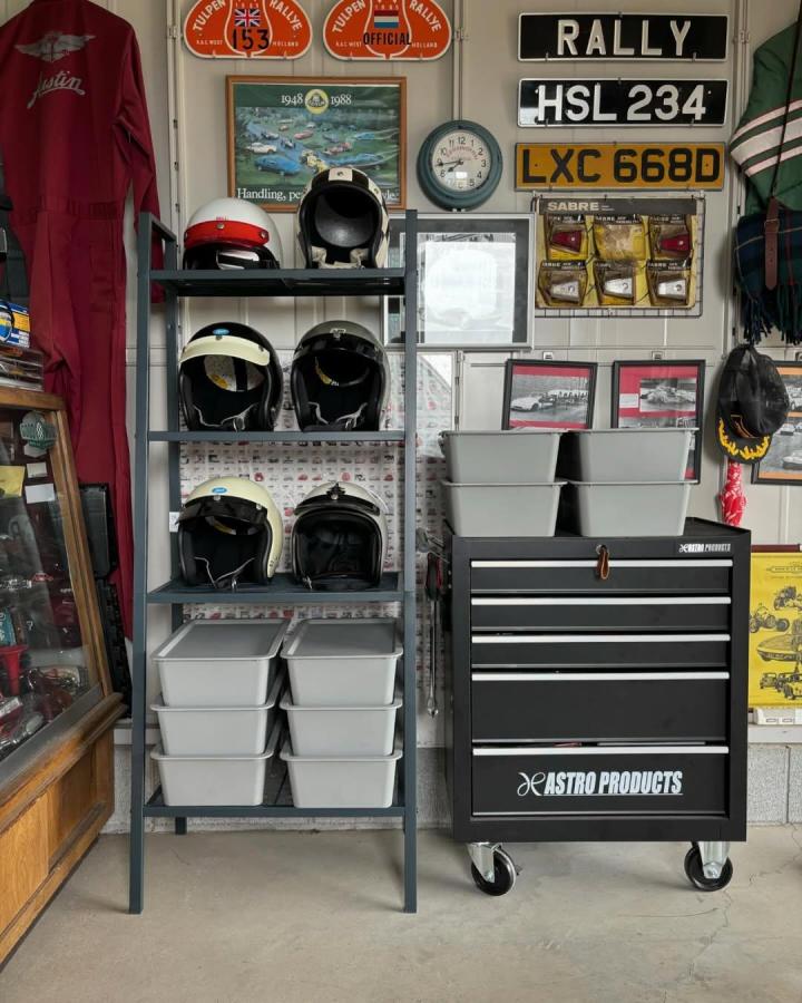 Gray metal shelving rack with helmet storage and gray bins in vintage-inspired garage by @asstyle_g1967 Organized and stylish storage solution.