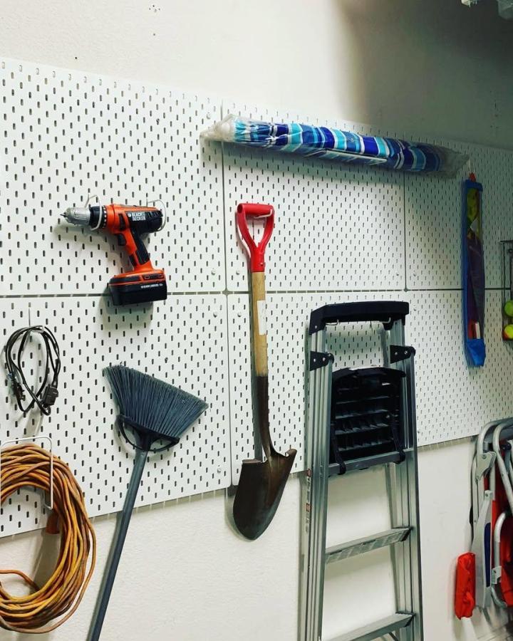 White SKÅDIS pegboard wall organizer by @janel_ralat_ with assorted tools and ladder for garage tool storage and easy access.