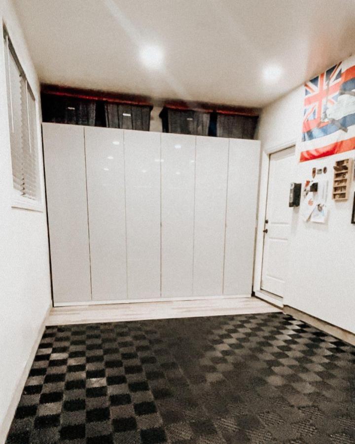 White glossy PAX cabinets with black storage bins in garage by @jujuuuu showcase ikea garage storage ideas with clean modern design and checkered flooring.