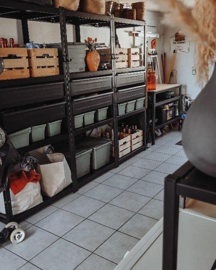 Black metal BROR shelving with wooden crates and green bins in garage by @we.under.one.roof functional and stylish storage solution.