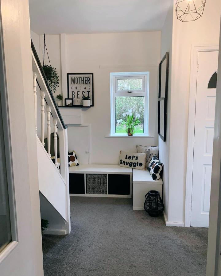 White and black built-in Ikea kallax entryway storage bench with cushions from @alittle_bit_creative used as a cozy seating nook beneath a window. ikea kallax entryway hacks.