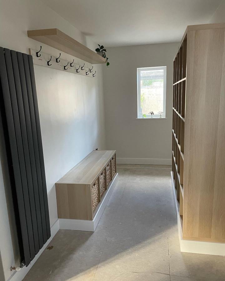 Light wood storage bench with wicker baskets and black hooks entryway design by @meldevelopmentsyorkshire practical and stylish storage solution.