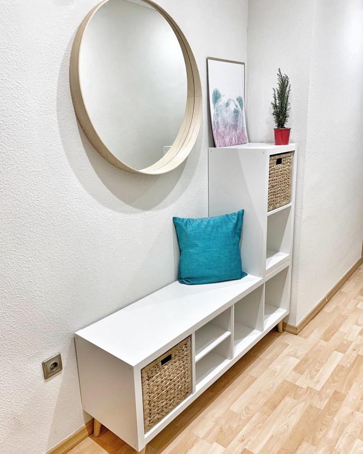 White Kallax bench with woven baskets and blue cushion in entryway from @ideasydecoenfamilia showing ikea kallax entryway hacks in minimalist style.
