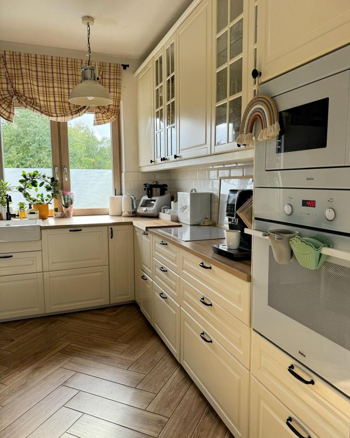 Cream toned IKEA BODBYN kitchen cabinets with glass doors and wood countertops from @domek_ani_pod_lasem showing smart storage and cozy style.