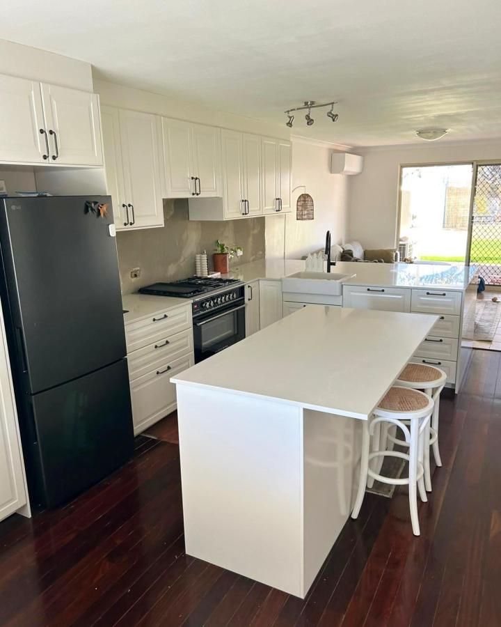 Bright white BODBYN style kitchen with large island and pull-out spice rack from @jb_kitchens_wa in bright natural light. Practical storage ideas.
