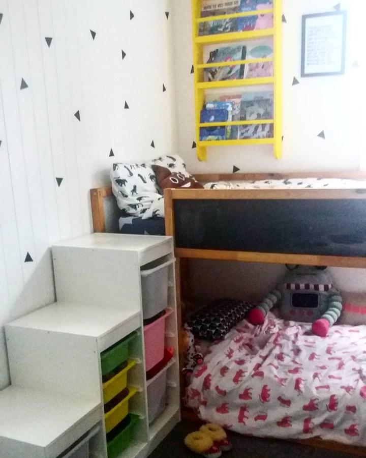 White stepped TROFAST storage unit next to wooden bed frame with chalkboard panel and colorful bins by @polish_mama_inuk for a kids room setup.
