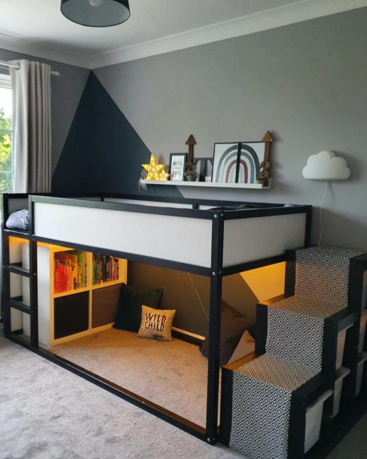 Painted black and white IKEA KURA loft bed with fabric-covered TROFAST storage steps and cozy reading nook from @yemsweetyem. Modern kids room design.