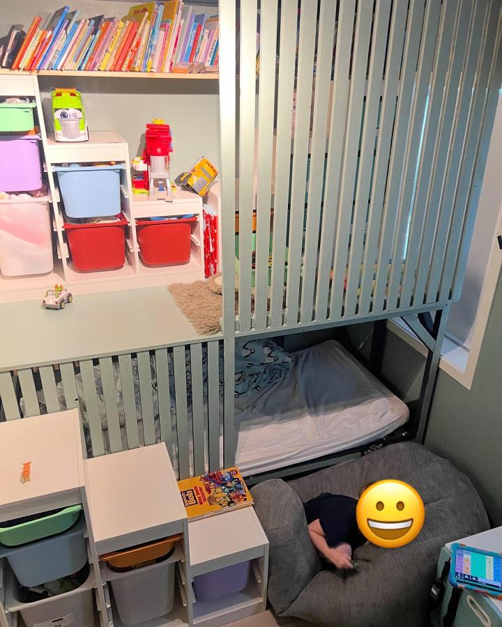 Light blue slatted loft bed with colorful organized bins and cozy sleeping nook from @maritkamu_facilitatormom. Creative kids room storage and privacy solution.