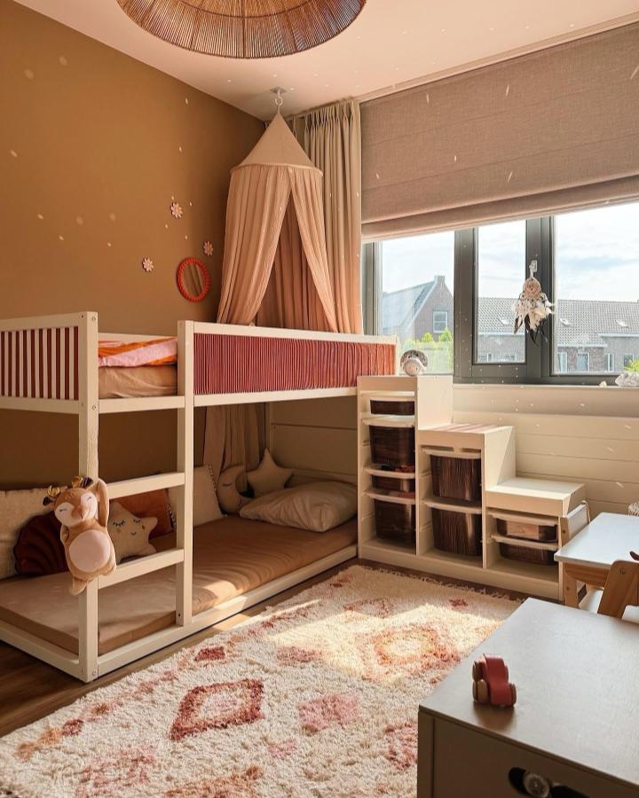 Blush and cream KURA bed with TROFAST storage staircase from @homebyrahs cozy kids room setup with soft cushions and canopy.