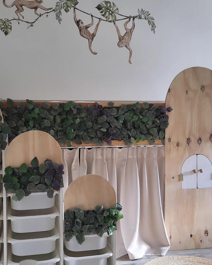 Natural wood and greenery kids treehouse bed with storage stairs by @elephantinthelivingroom. Cozy, playful, and functional children's room design.