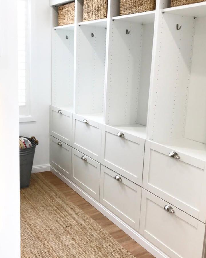 Bright white mudroom storage lockers with woven baskets and silver handles from @mad_about_design_by_lucinda. Organized built-in style with natural texture contrast.