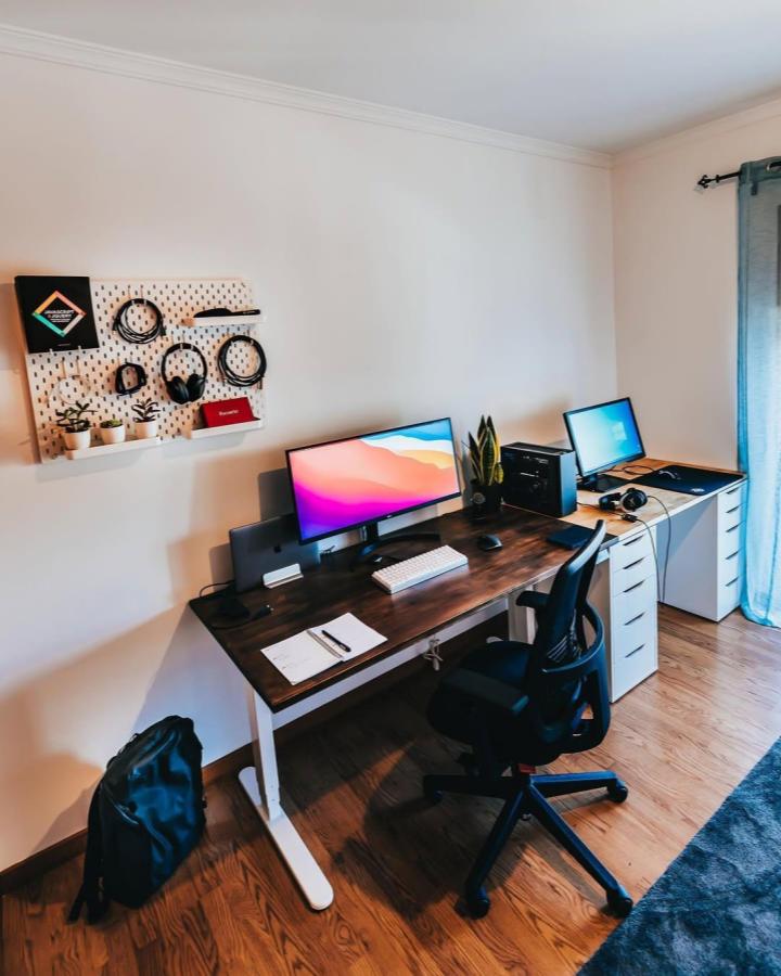 White pegboard organizer with black tech accessories and green plants in modern home office by @fidalgo.dev bright minimalist workspace wall mount.