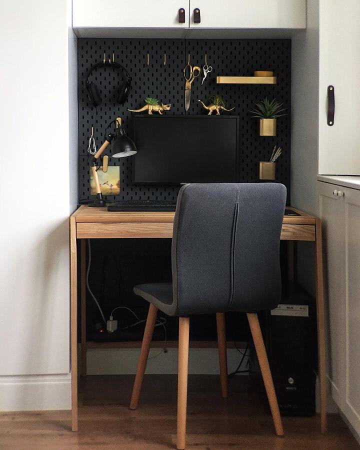 Black perforated pegboard office nook with gold hooks and shelves by @foxyandbrass featuring quirky decor and practical storage.