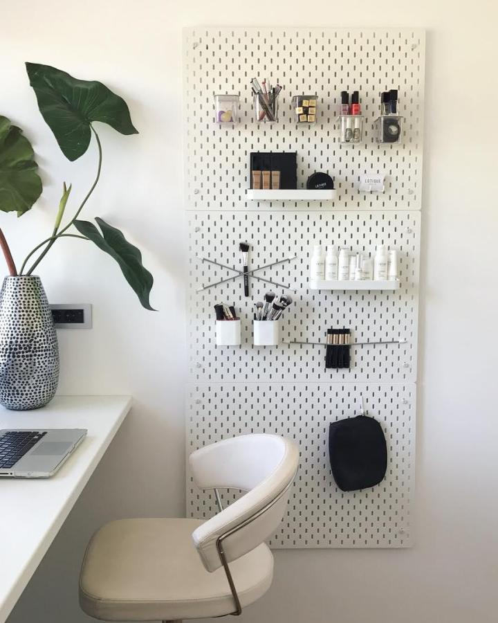 White minimalist pegboard organizer from @nikaveger featuring modular shelves, hooks, and clear containers for tidy office essentials.