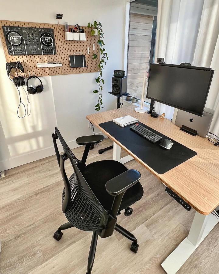 Natural wood pegboard wall organizer with tech gear and plants by @gaurangalat in a bright home office setting. Clean and stylish.